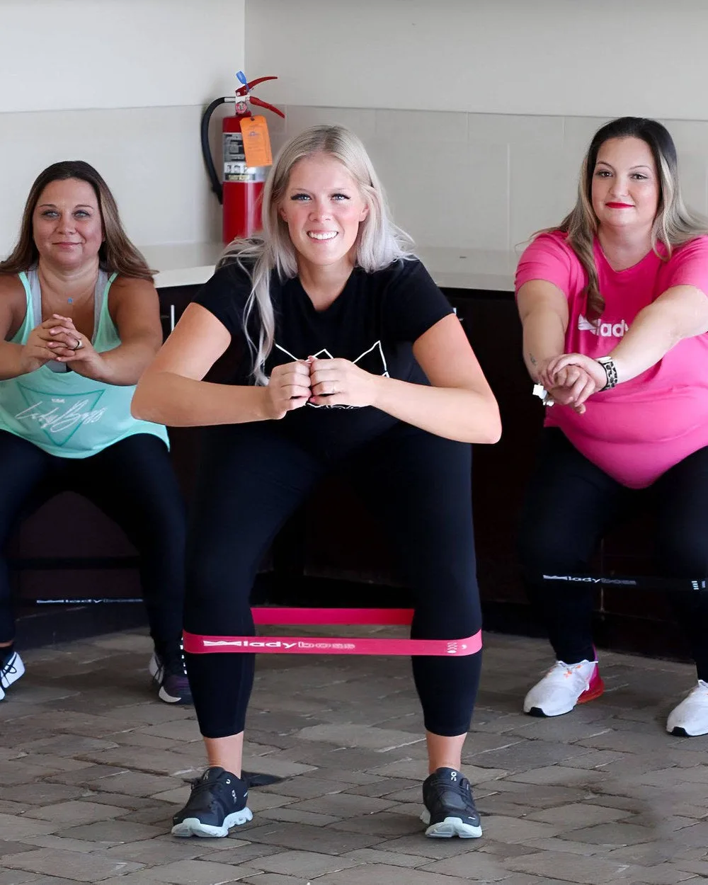 LadyBoss members training with a resistance band
